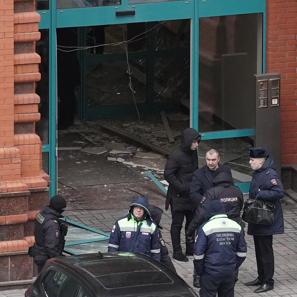 Officers standing outside a brick building.