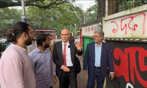 El Alto Comisionado para los Derechos Humanos, Volker, con unos estudiantes que le muestran las pintadas realizadas durante la protesta de julio cerca de la Universidad de Dhaka, Bangladesh.