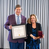 a man holding an award and a woman holding an award