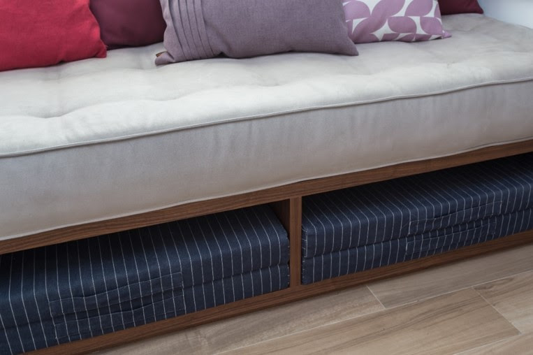 Algumas estruturas possuem espaços tão amplos que é possível guardar outros futons, caso sejam feitos com mais de uma almofada e espuma compacta, como os dobrados no projeto do home office. | Projeto: Studio Tan-gram | FOTO: Estúdio São Paulo