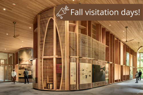 The interior of a curved wooden building with museum style exhibits.