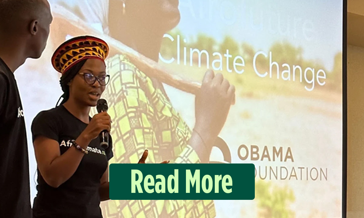 A woman with a dark skintone is speaking and holding a mircrophone next to a projector that says "Climate Change". At the bottom of the image, a button reads "Read More"