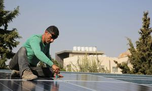 Un trabajador instala un panel solar en Jordania.