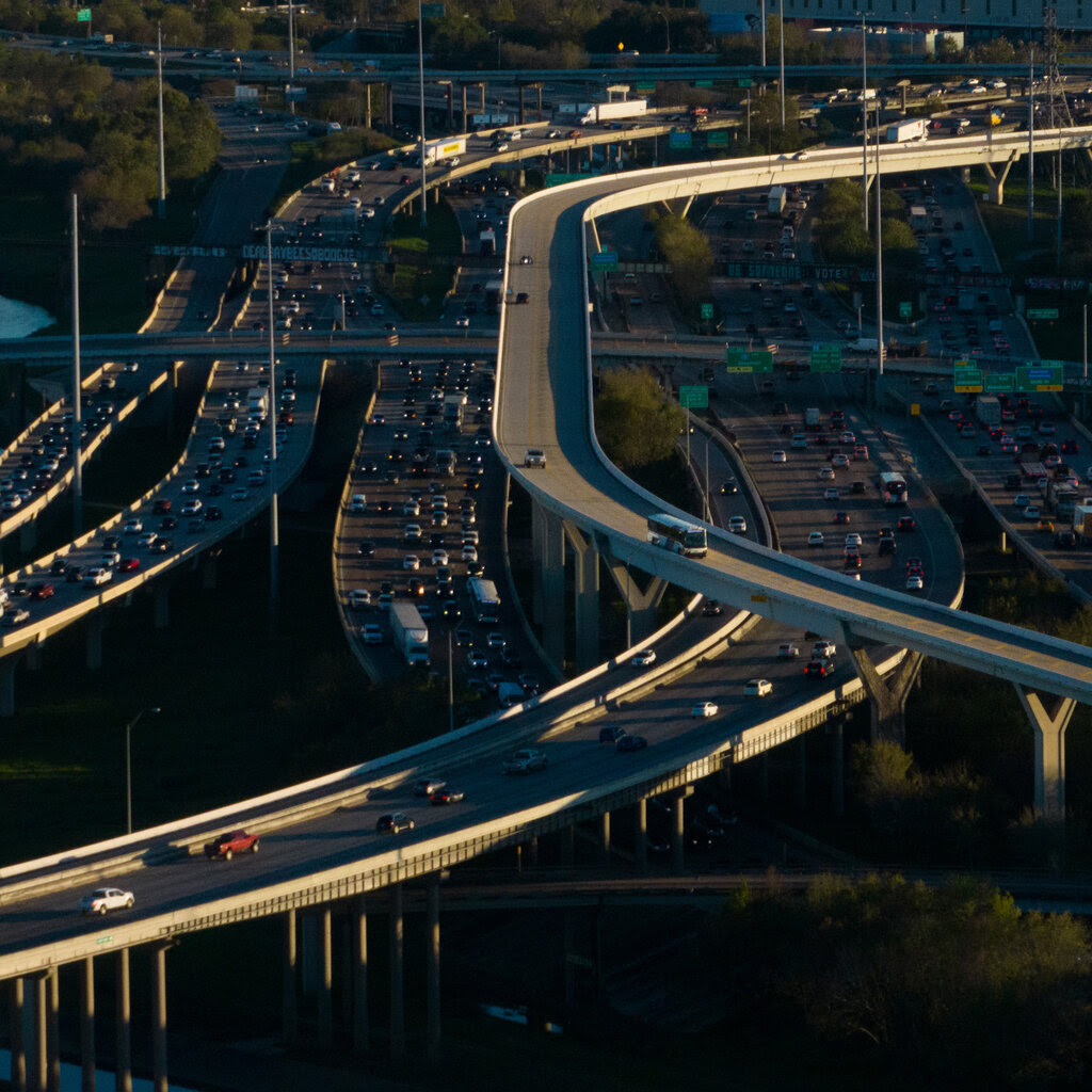 An aerial view of a complex network of highways filled with cars.