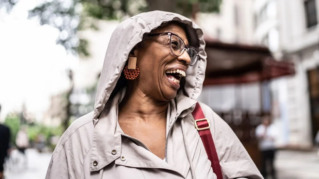 Female outside wearing glasses and laughing