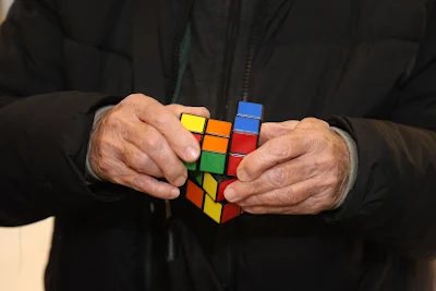 Primeros planos de manos resolviendo un cubo Rubik 3x3, demostrando técnicas rápidas y eficientes