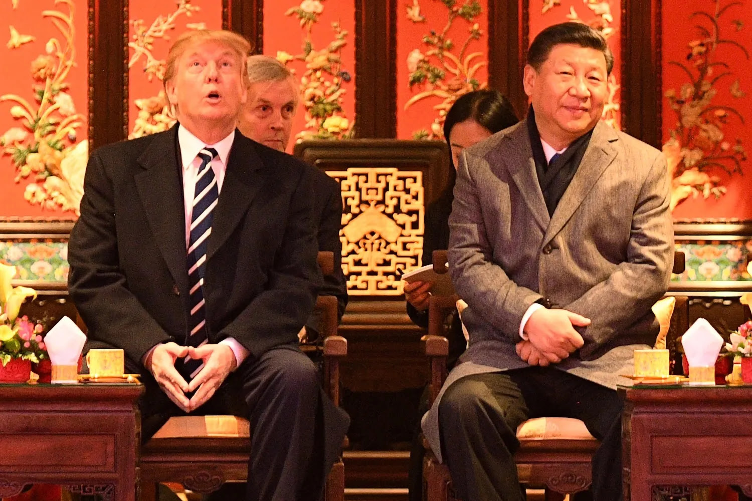 Donald Trump looks up as he sits beside China's President Xi Jinping during a tour of the Forbidden City in Beijing on Nov. 8, 2017. 