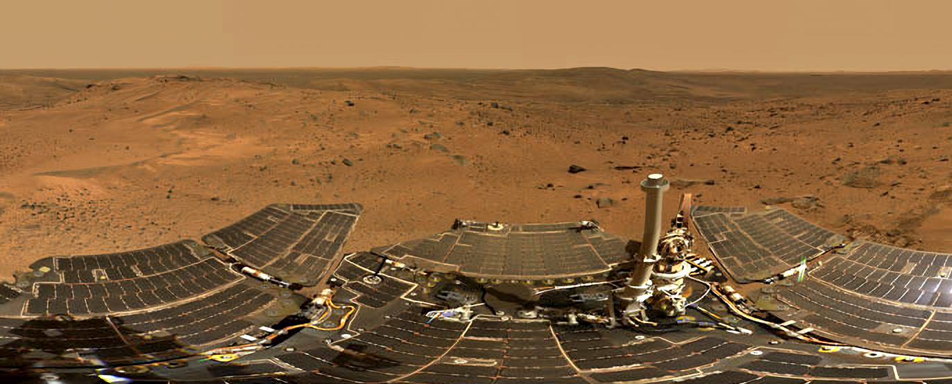 Part of a rover is visible against the rocky surface of Mars.