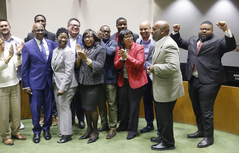 Dallas Black Chamber of Commerce Harrison L. Blair (right) flexes as City Manager T.C....