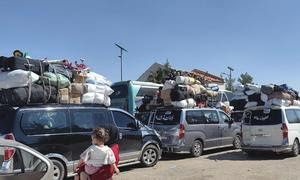 Vehículos con familias que de los bombardeos israelíes en Líbano llegan a la frontera con Siria.