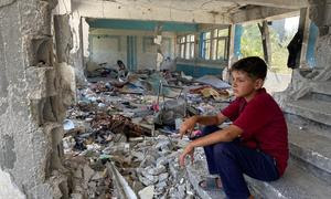 Un niño sentado entre las ruinas de una escuela en el centro de Gaza en junio de 2024.