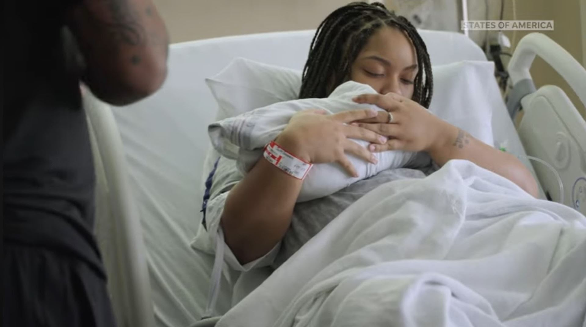 A woman holding a baby in a hospital bed