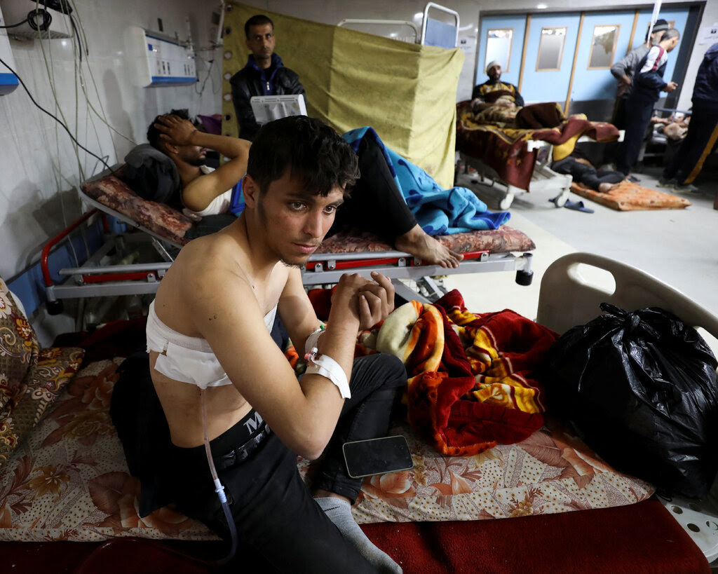 Wounded people on beds at a hospital.
