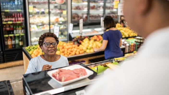 Woman buying meat in a supermarket.