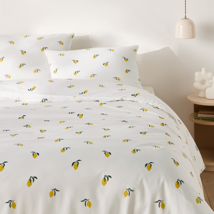 A bed with white sheets and yellow lemons on itAI-generated content may be incorrect.