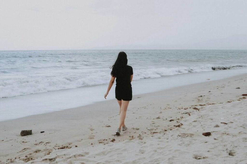 una ragazza cammina sulla spiaggia