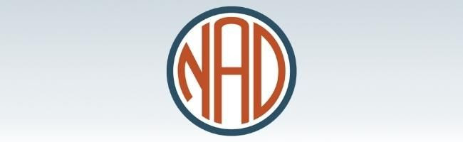 Ombre background of gray top to white bottom. The NAD logo is in red, blue and white in the center.