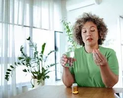 woman meditating with a bottle of menopause supplement