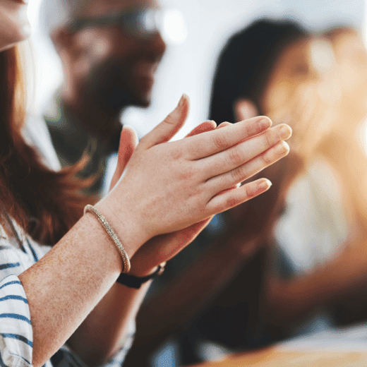 Woman clapping at employee engagement event.