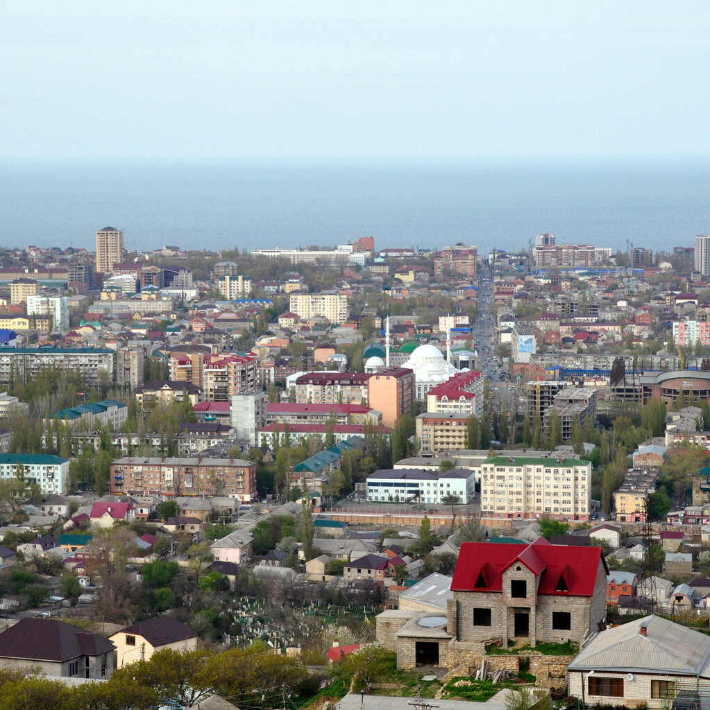 A view from above of a city. The Caspian Sea is in the background.