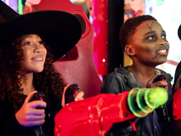 Kids playing games in their Halloween costumes at Chuck E. Cheese