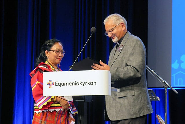 Norma P. Dollaga listens as Bishop Ivan Abrahams reads the citation for the 2024 World Methodist Peace Award on Aug. 15 during the World Methodist Conference in Gothenburg, Sweden. Dollaga, a United Methodist deaconess, is being recognized for her efforts to stop extrajudicial killings in the Philippines. United Methodist Bishop Christian Alsted also was honored with a peace award for his work in Ukraine. Abrahams is the outgoing general secretary of the World Methodist Council. Photo by Heather Hahn, UM News.