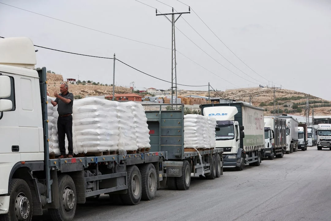 Commercial food trucks are seen near a checkpoint near Hebron