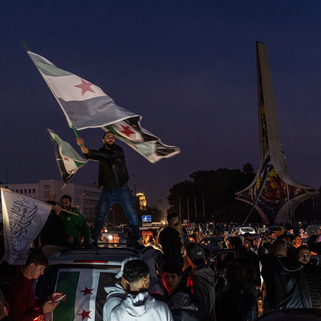 People wave flags and fill the streets of Syria’s capital, Damascus.