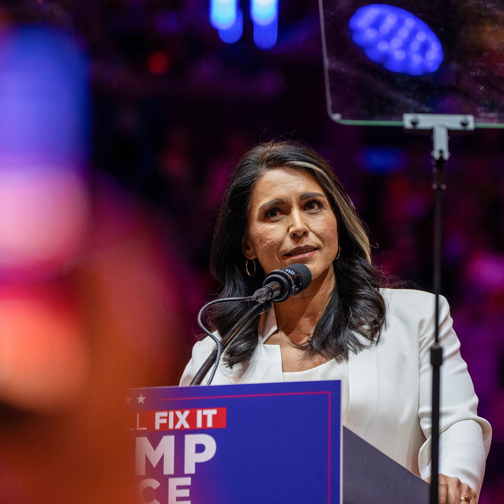 Tulsi Gabbard speaking from the lectern at a Trump campaign rally.