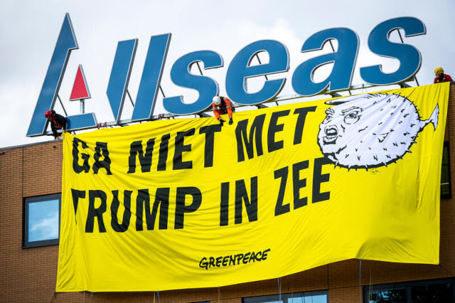 Actievoeders hangen een spandoek op bij Allseas met de tekst 'Ga niet met Trump in zee'