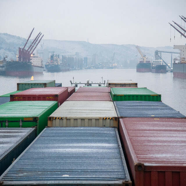 Shipping containers on a cargo boat on a river.