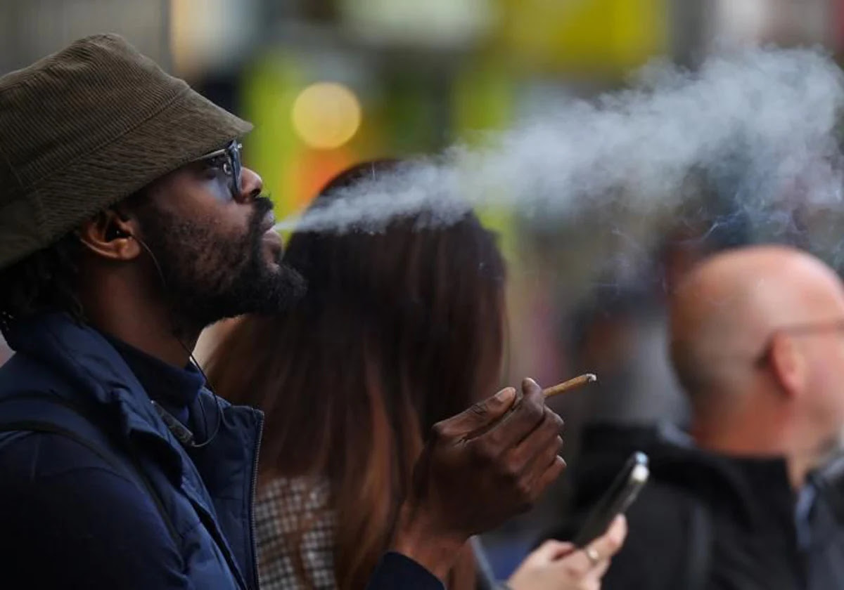 Un hombre fuma en las calles de Londres este lunes, mientras el Parlamento estaba discutiendo la medida