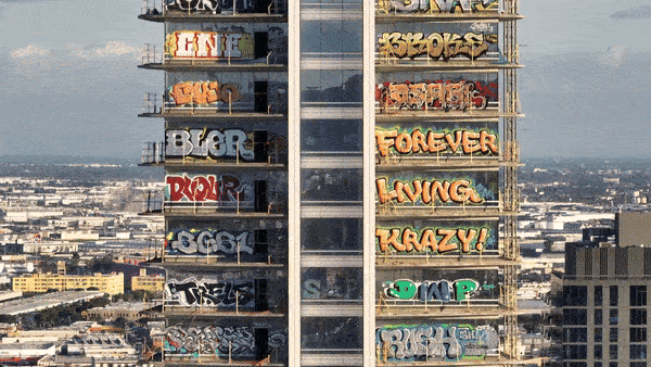 A gif shows a skyscraper with big graffiti words on almost every floor or balcony. 