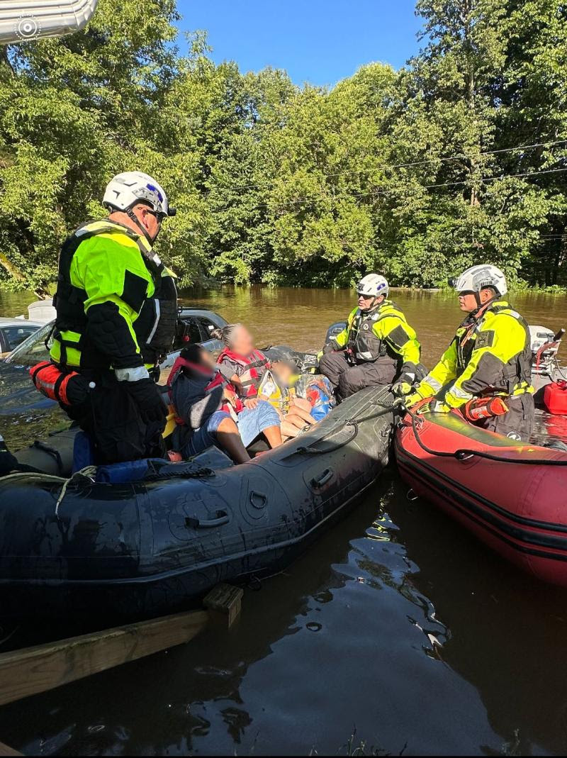 ECOs and New York State Fire in rescue boats with a family during a flood