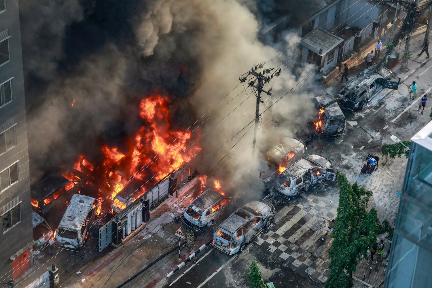 Smoke rises from burning vehicles after protesters set them on fire near the Disaster Management Directorate office in Dhaka.