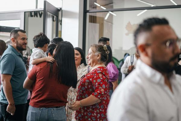 A diverse group of people gather to chat in a church lobby. 