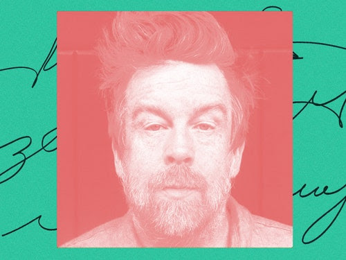 A photo of Kevin Barry in red. The background has some cursive writing on a green background.