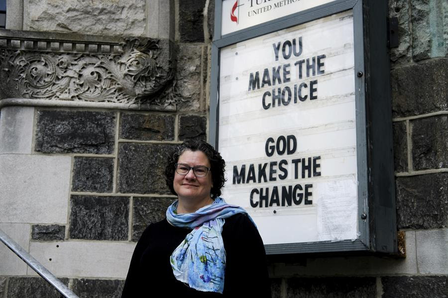 Beth Stroud stands in front of a church sign that says "You make the choice. God makes the change."