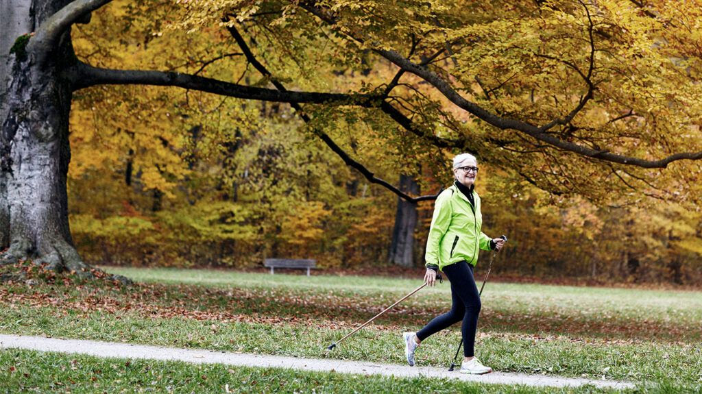 Woman walking by trees in fall-1