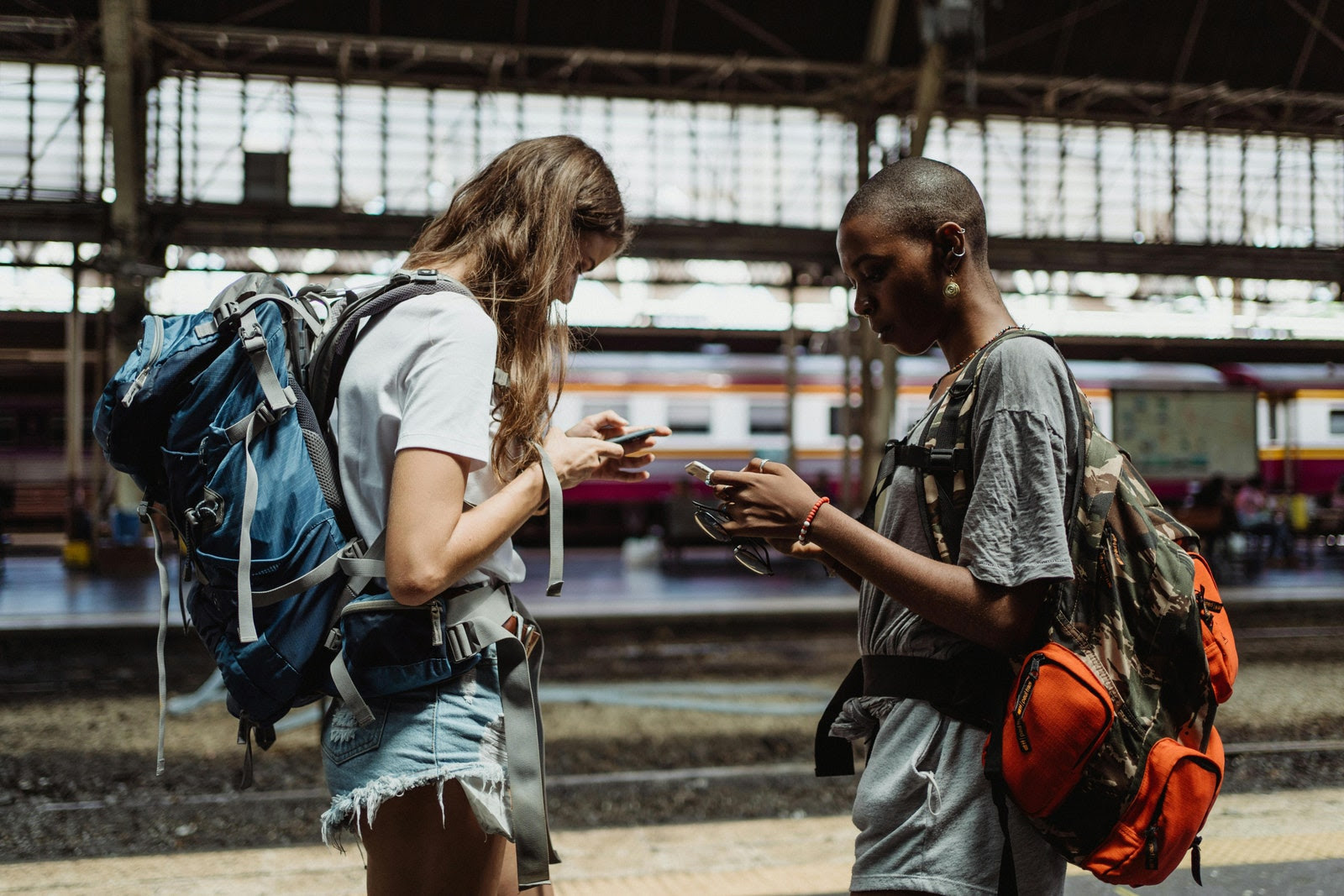 dos mujeres con mochilas en su celular