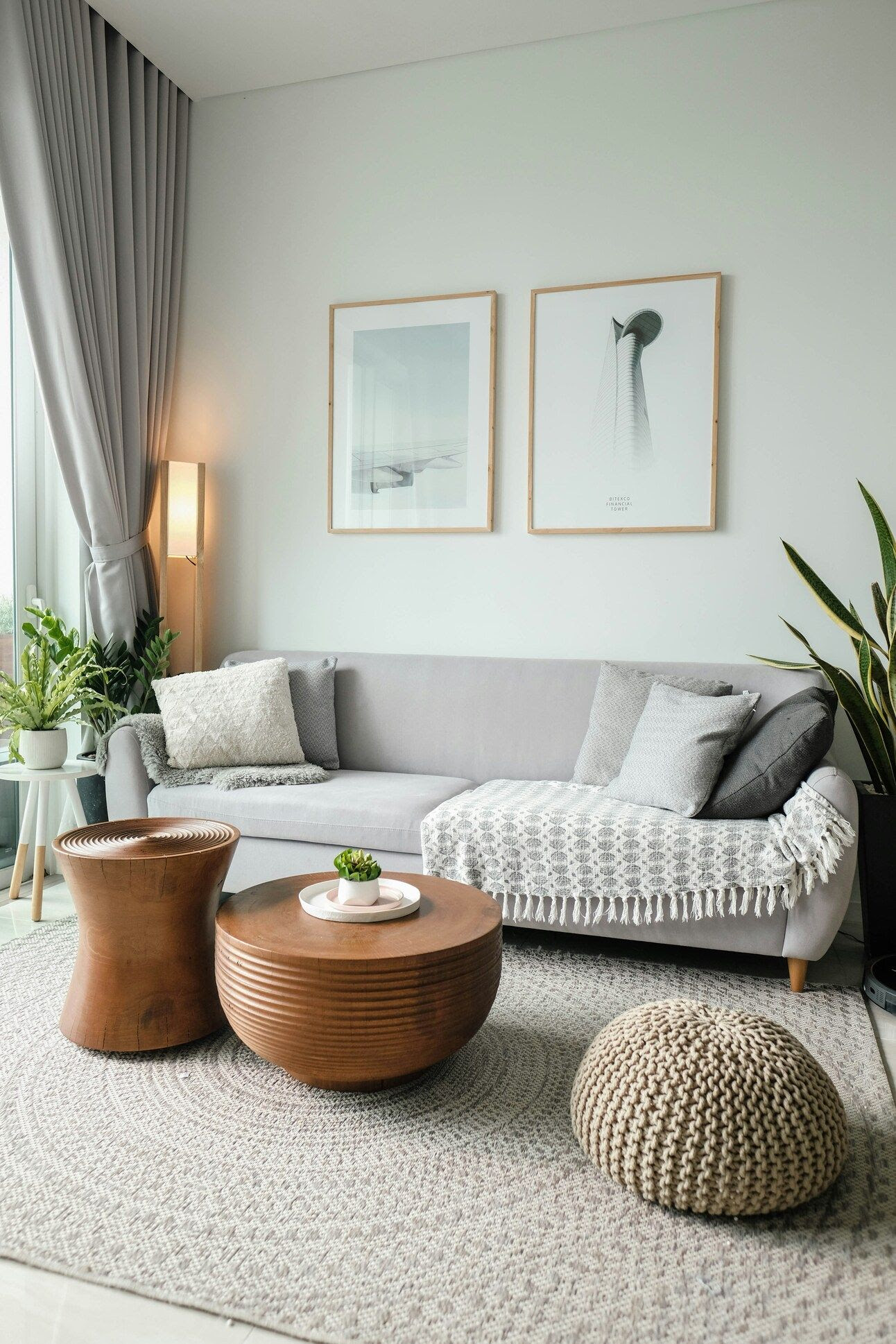 Photo of living room with coffee tables, couch with throws and pillows, art, and potted plants