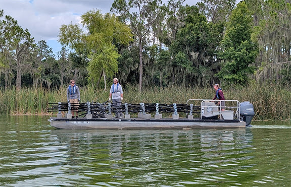 Staff deploying fish attractors from a boat