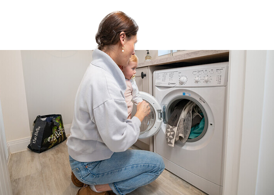 A lady and daughter loading a washing machine