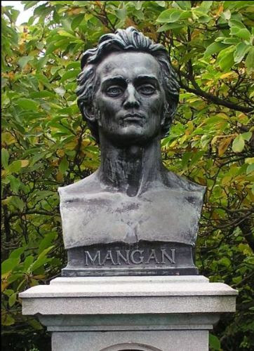 A bust of writer James Clarence Mangan, behind which is a verdant bush