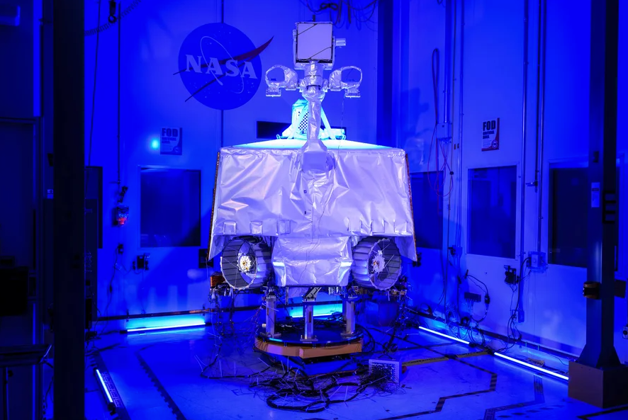 The VIPER rover in a blue-lit clean room at NASA's Johnson Space Center