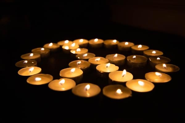 Candle votives lit in the shape of a peace sign in the dark