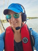 Boat crew member taking a selfie while wearing a headset and lifejacket