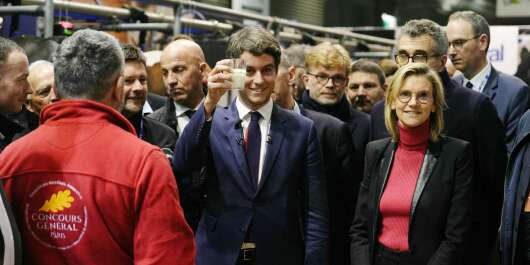 French Prime Minister Gabriel Attal holds a glass of milk near Deputy Minister for Agriculture and Food Sovereignty Agnes Pannier-Runacher (R) and Minister for Agriculture and Food Sovereignty Marc Fesneau as they visit the 60th International Agriculture Fair (SIA - Salon de l'Agriculture), at the Porte de Versailles exhibition centre in Paris on February 27, 2024.
