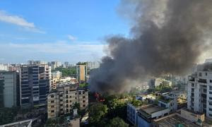 Sale humo de una tienda incendiada por manifestantes en Dhaka, Bangladesh.