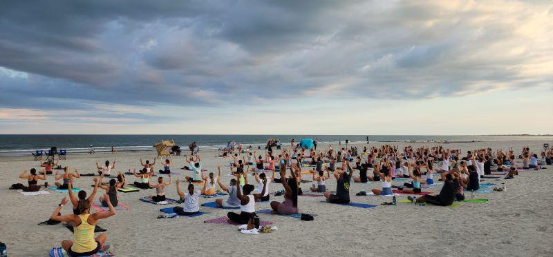 Peole practicing yoga on the beach at sunset